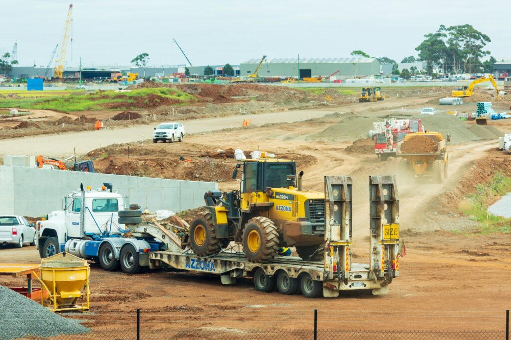 yellow and black heavy equipment on brown field during daytime