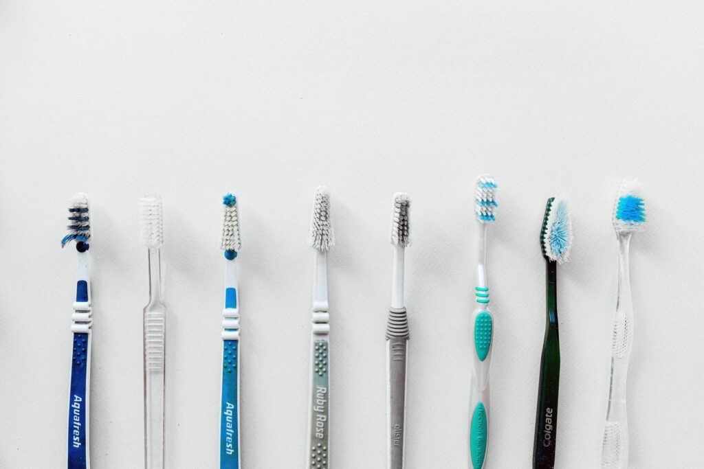 Diverse selection of toothbrushes lined up for dental hygiene focus with copy space.